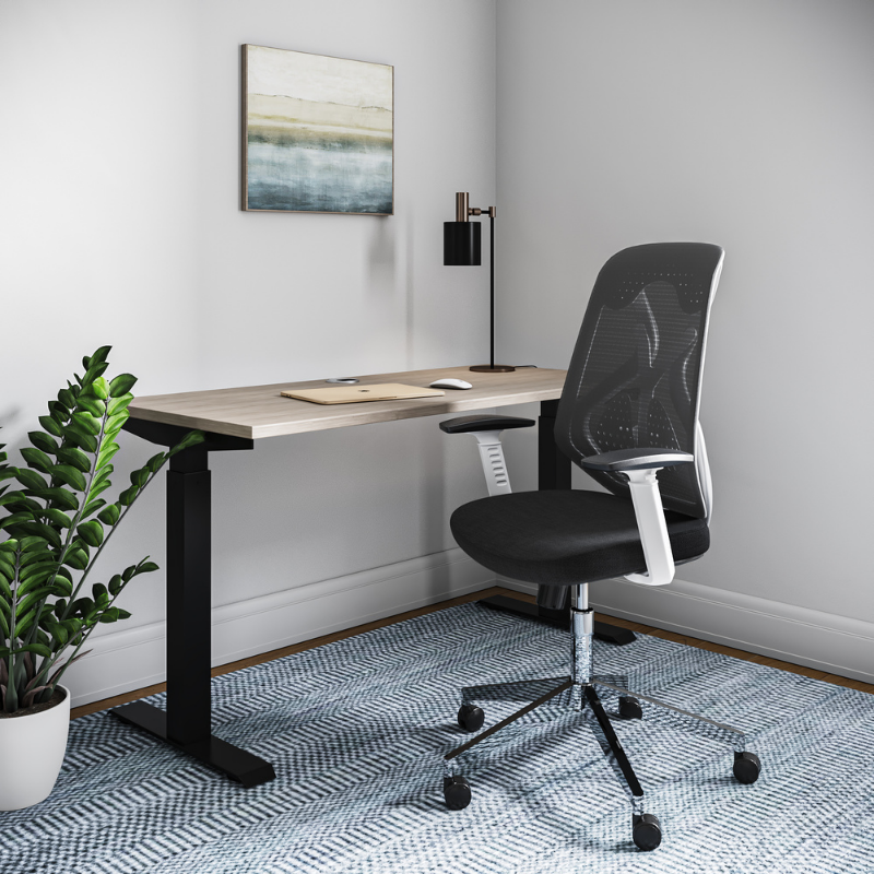 White ergonomic office chair in front of standing desk